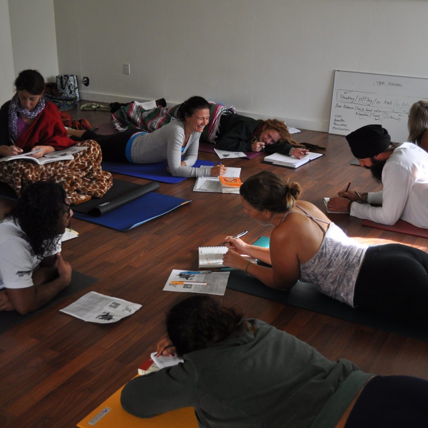 Group of young people lying on the floor writing in notebooks | Santosh Yoga Institute in Salt Lake City, UT
