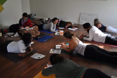 Group of young people lying on the floor writing in notebooks | Santosh Yoga Institute in Salt Lake City, UT