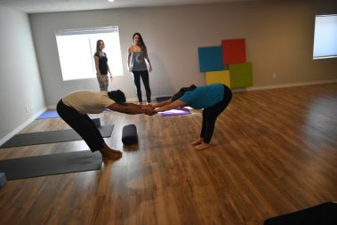 Young female practicing yoga with man | Santosh Yoga Institute in Salt Lake City, UT