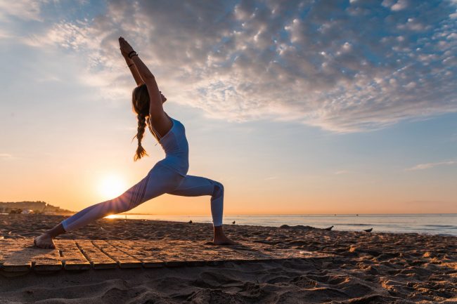 Flexible woman doing hard excersise outdoors | Santosh Yoga Institute in Salt Lake City, UT