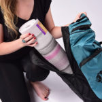Woman Putting Ultra Yoga Mat in Bag in Salt Lake City, UT | Santosh Yoga Institute