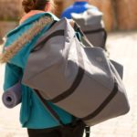 Woman holding Yoga Pro Duffel Bag on her back in Salt Lake City, UT | Santosh Yoga Institute