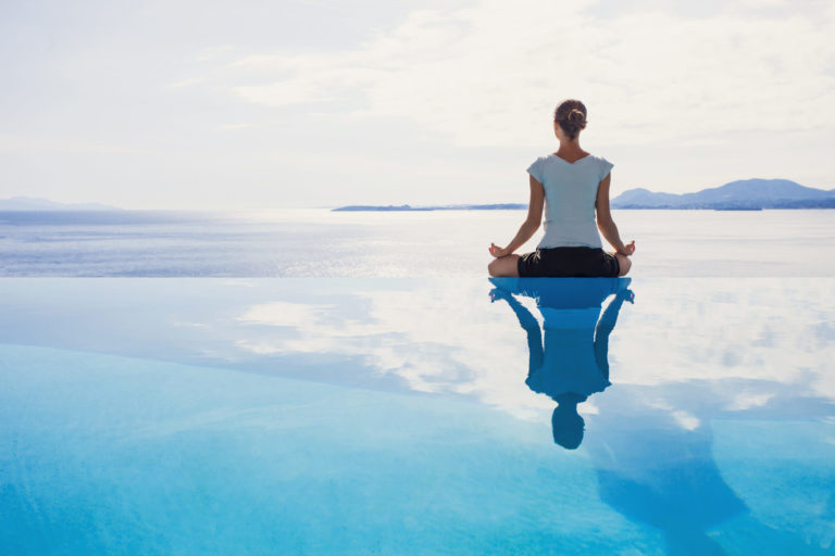 Woman sitting in a beautiful calm place doing meditation in Salt Lake City, UT | Santosh Yoga Institute