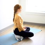 Woman doing meditation while sitting on Sukasana Cushion in Salt Lake City, UT | Santosh Yoga Institute