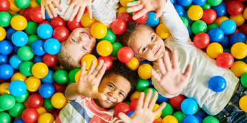 Cute kids lying on balls showing their hands in Salt Lake City, UT | Santosh Yoga Institute