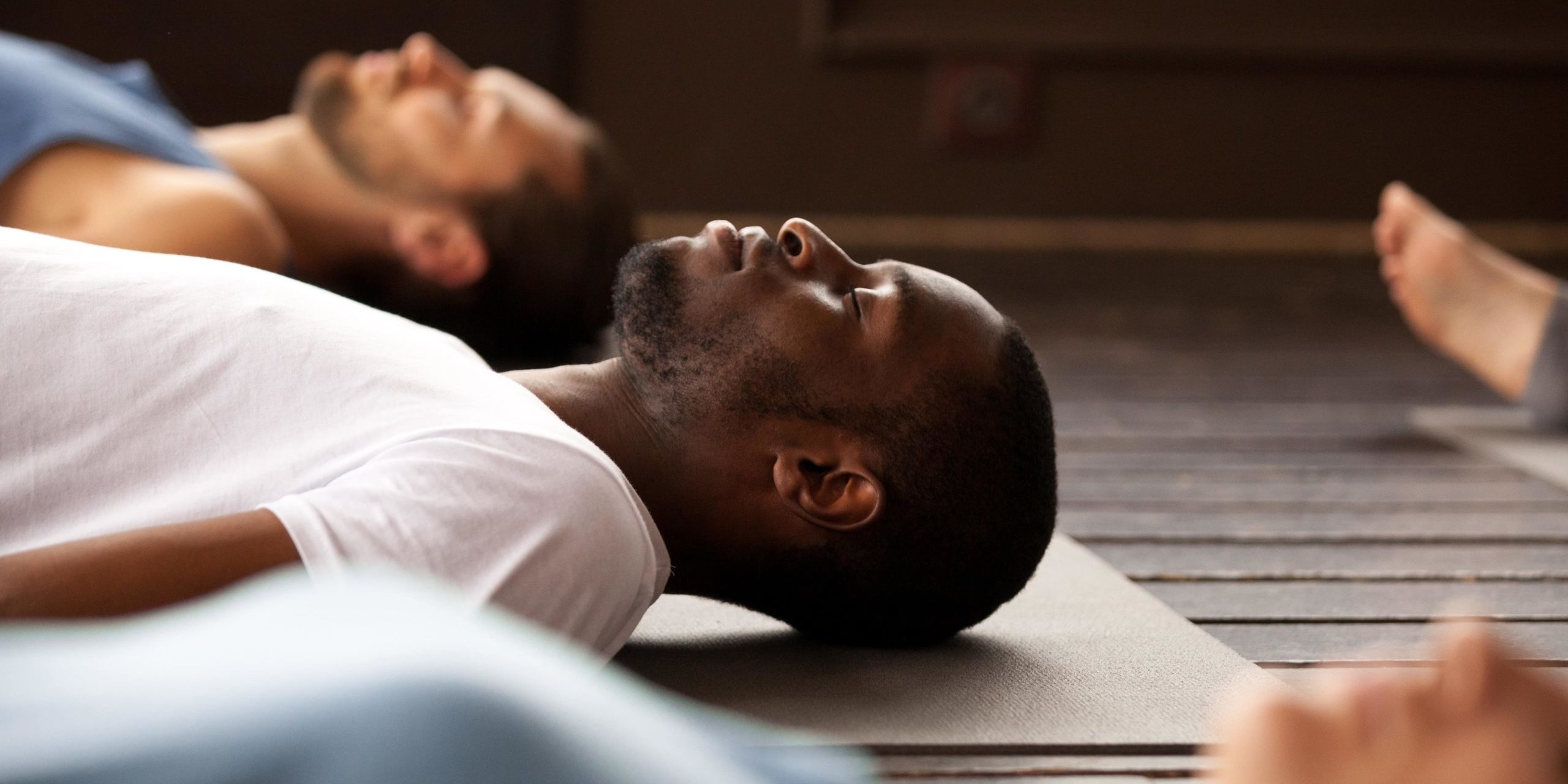 Group of young people lying on the exercise mat and doing relaxation exercises in Salt Lake City, UT | Santosh Yoga Institute