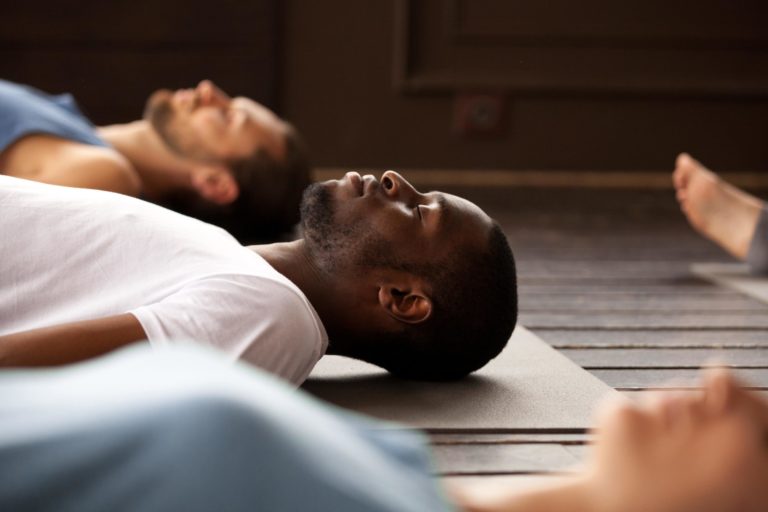 Group of young people lying on the exercise mat and doing relaxation exercises in Salt Lake City, UT | Santosh Yoga Institute