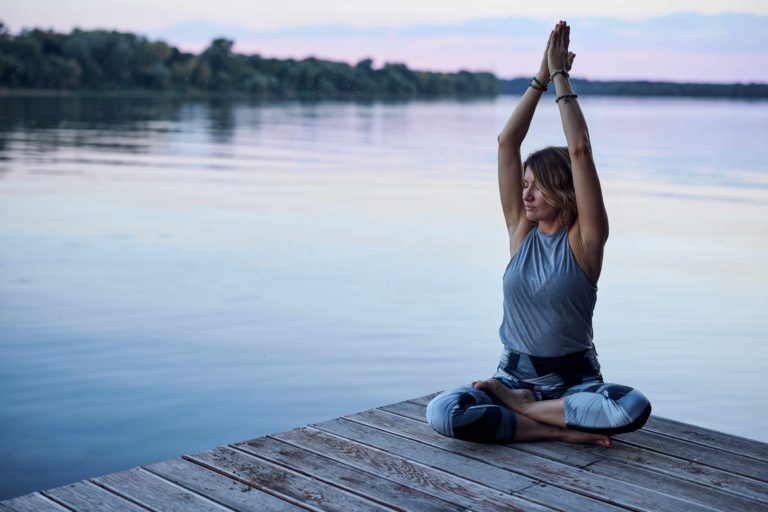 Young girl doing pranayama next to beautiful lake in Salt Lake City, UT | Santosh Yoga Institute
