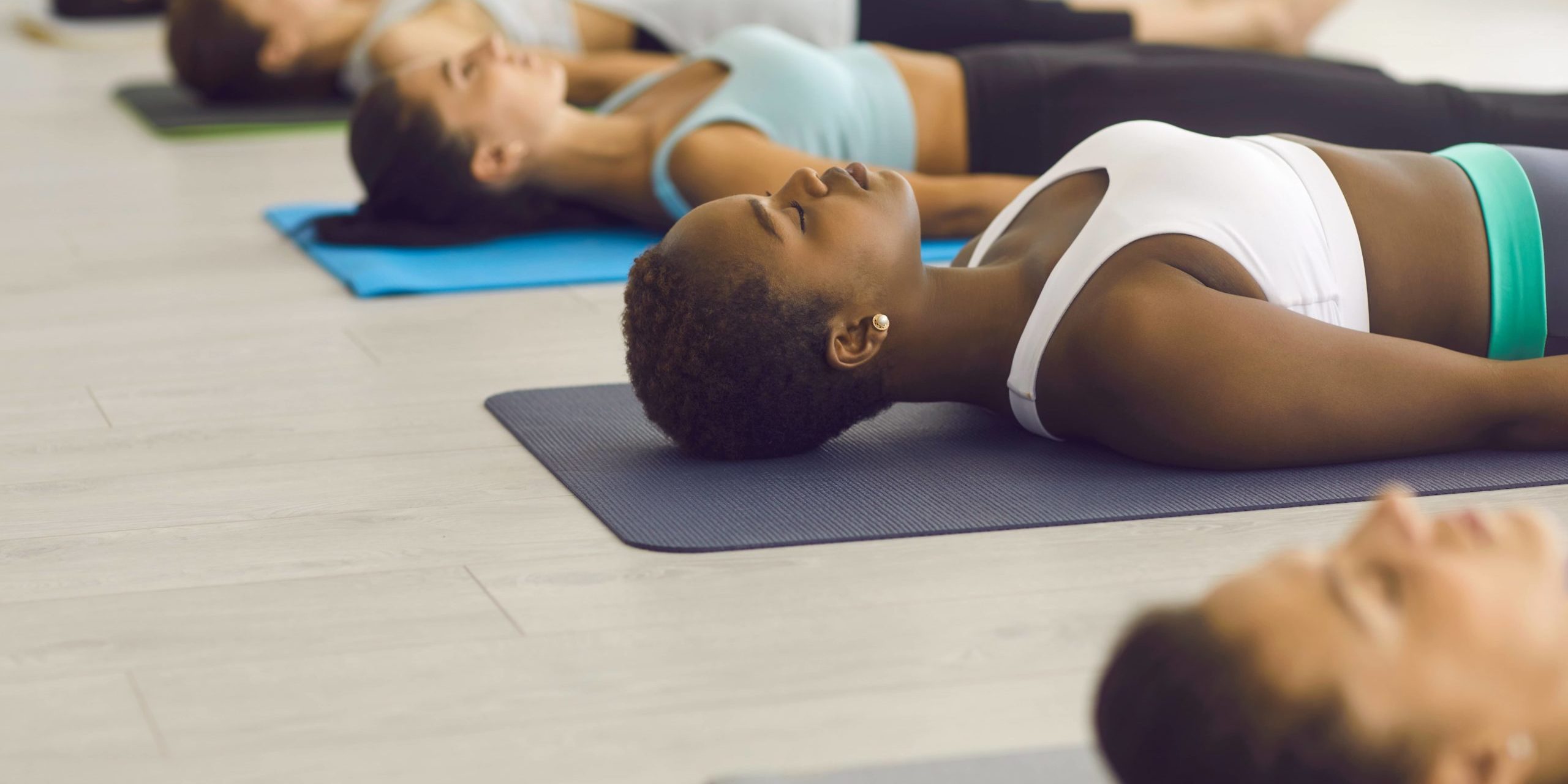 Group of young girls lying on the exercise mat and doing relaxation exercises in Salt Lake City, UT | Santosh Yoga Institute