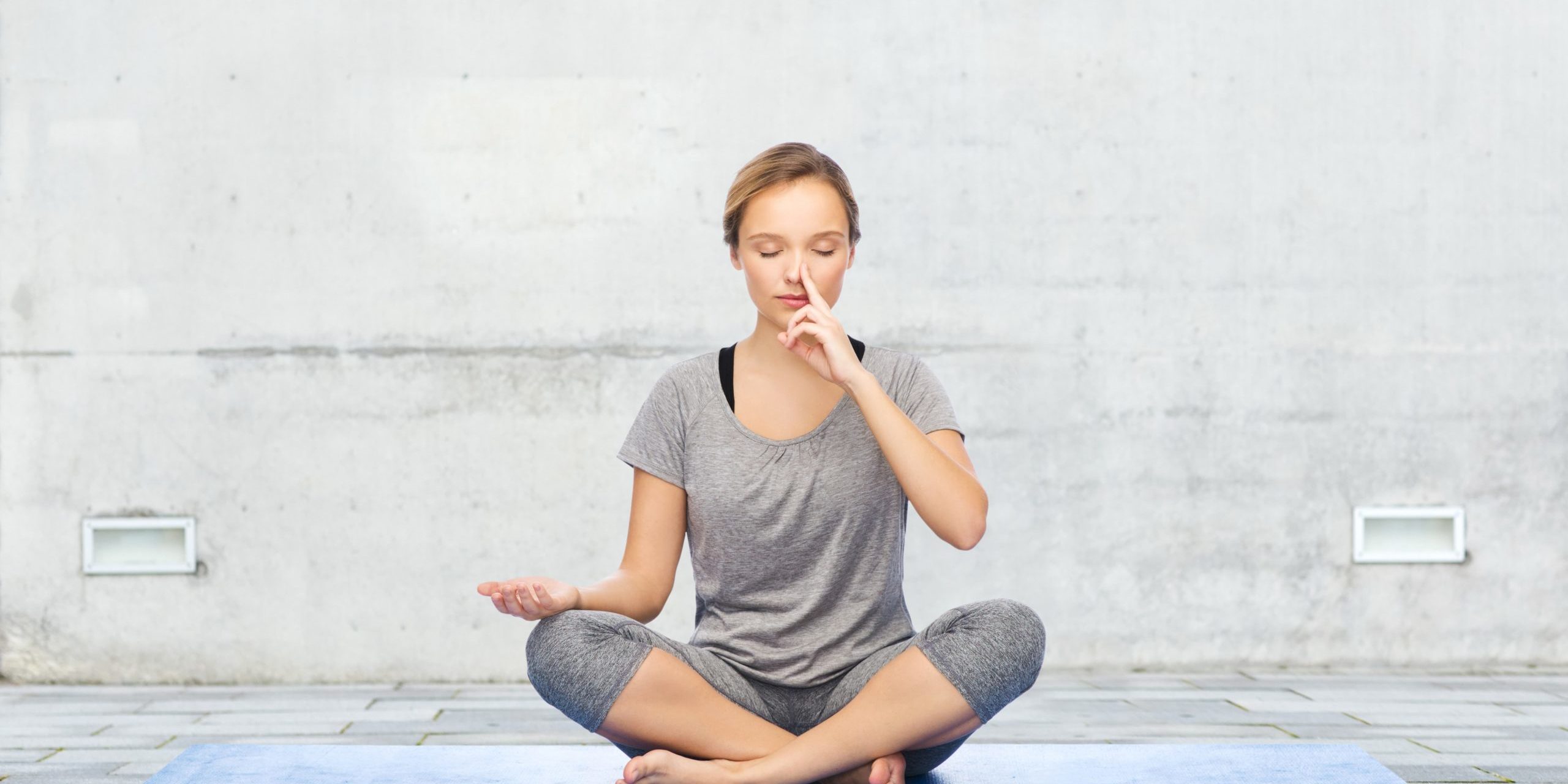 Young girl doing nostril breathing exercise or pranayama yoga in Salt Lake City, UT | Santosh Yoga Institute
