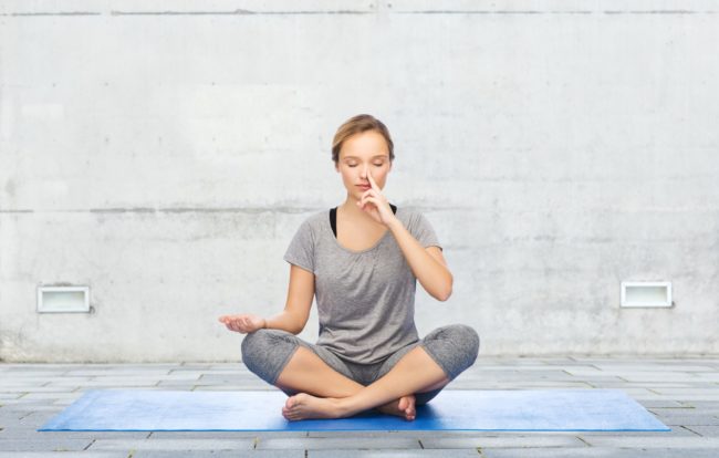 Young girl doing nostril breathing exercise or pranayama yoga in Salt Lake City, UT | Santosh Yoga Institute