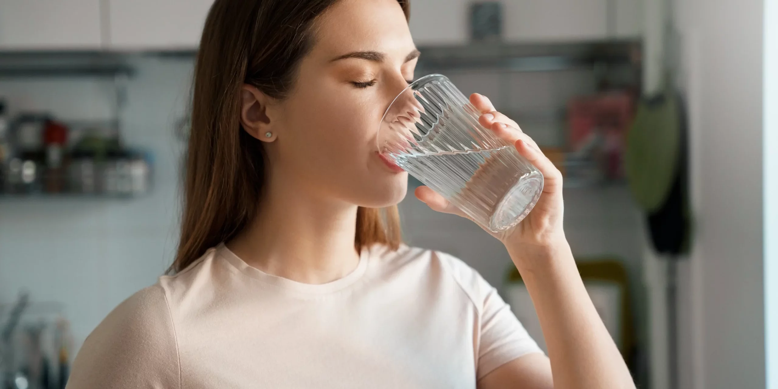 Young woman drinking water in Salt Lake City, UT | Santosh Yoga Institute