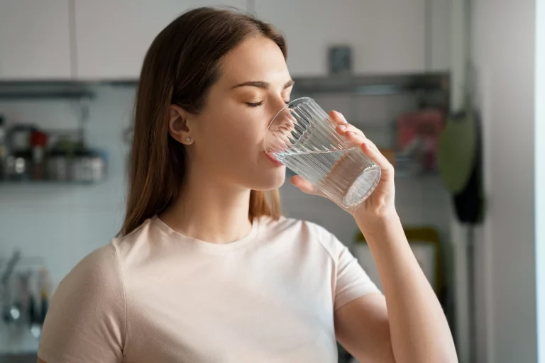 Young woman drinking water in Salt Lake City, UT | Santosh Yoga Institute