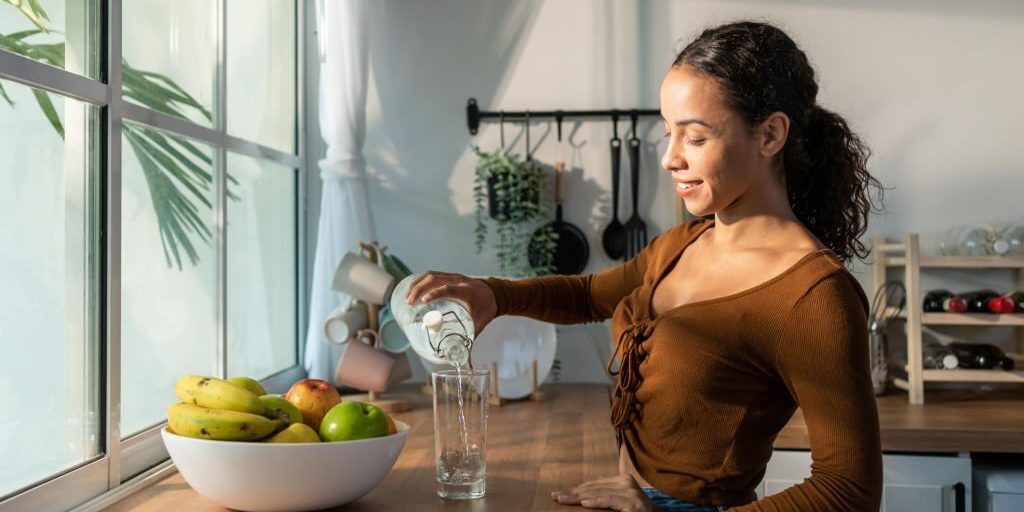 Young girl pouring a glass of water in Salt Lake City, UT | Santosh Yoga Institute