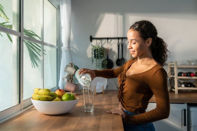 Young girl pouring a glass of water in Salt Lake City, UT | Santosh Yoga Institute