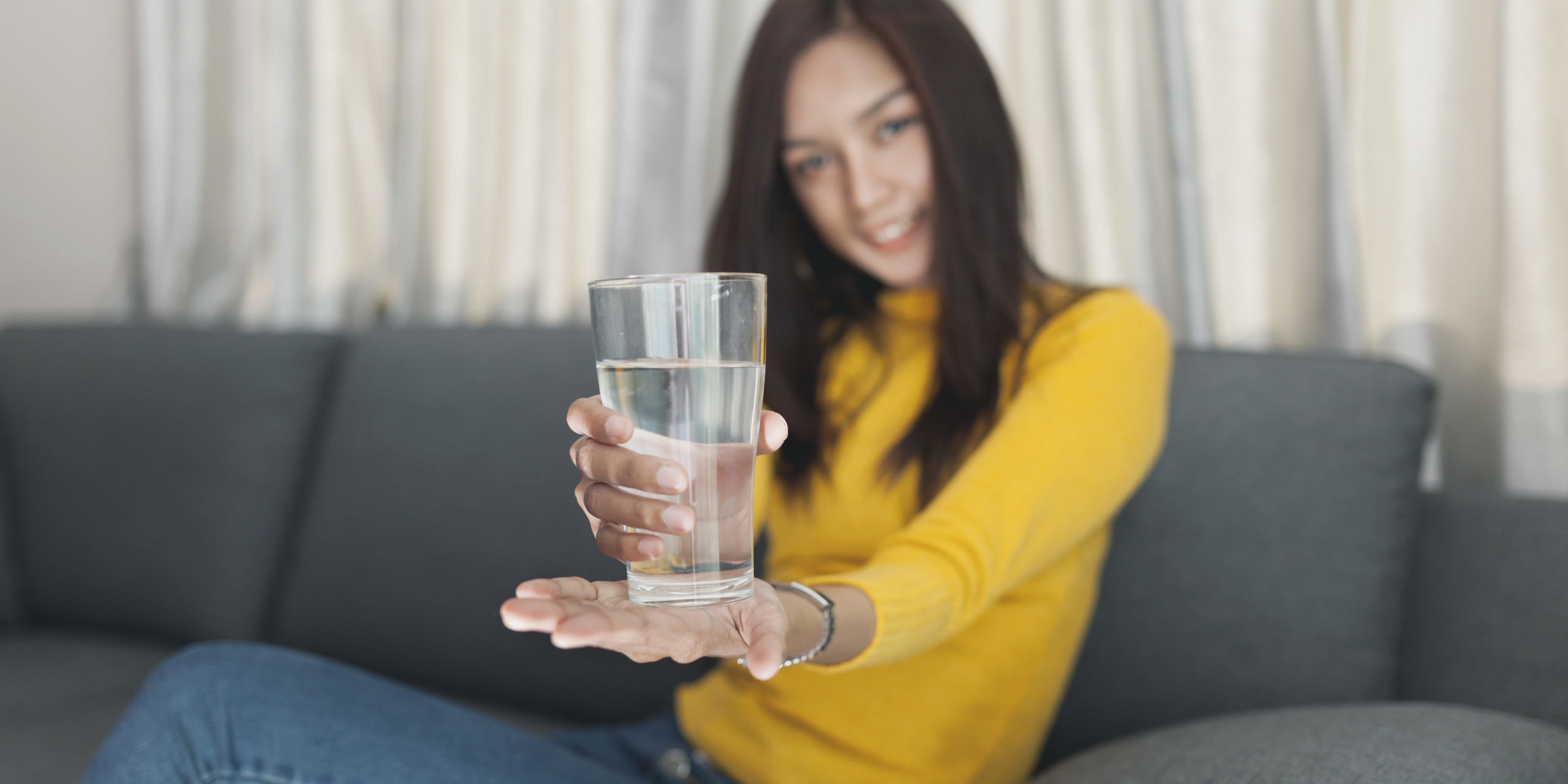 Young girl holding glass of water in hands in Salt Lake City, UT | Santosh Yoga Institute