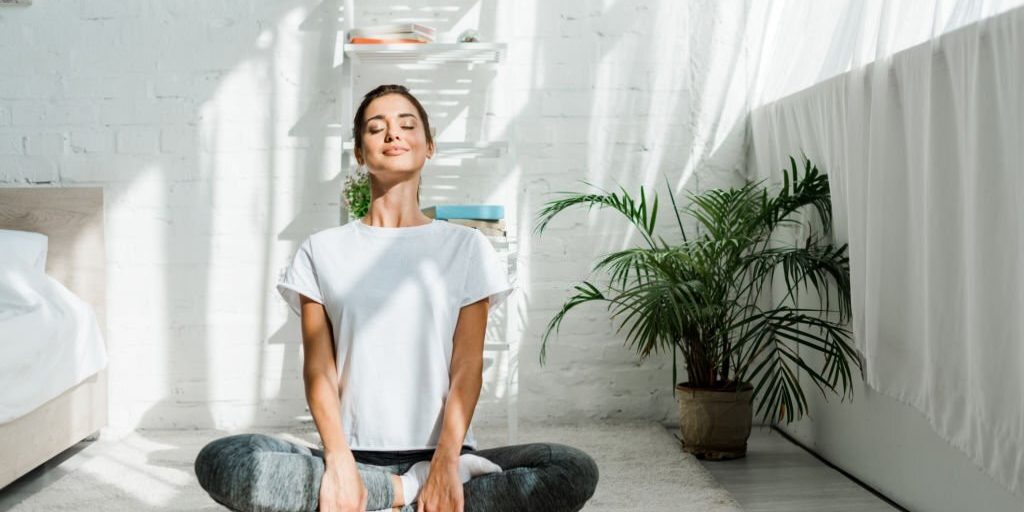 Relaxing closed eyes woman doing yoga at home in Salt Lake City, UT | Santosh Yoga Institute