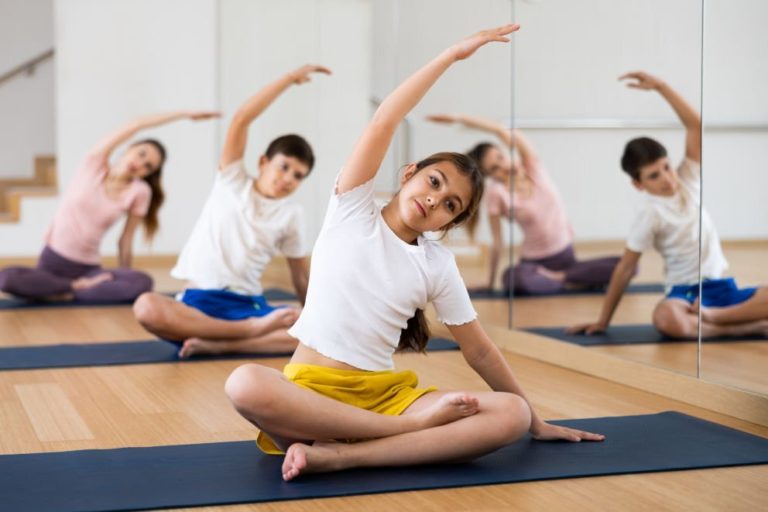 Children are sitting on a mat and doing yoga in Salt Lake City, UT | Santosh Yoga Institute